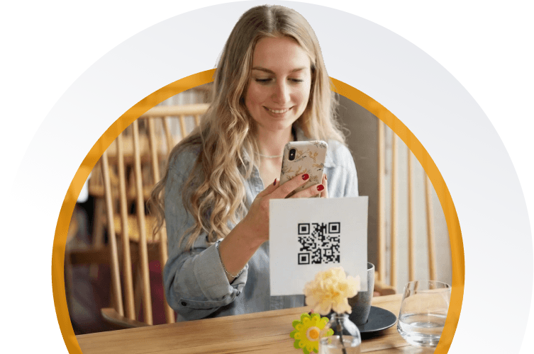 Gość restauracji skanuje kod QR na stole, aby otworzyć cyfrowe menu na smartfonie